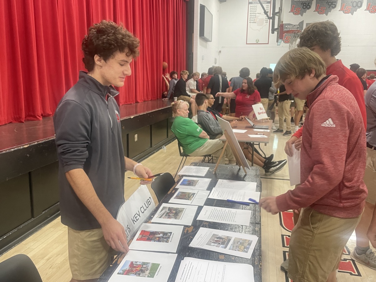 Students stand in line at tables